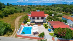 A large house with a swimming pool, a tennis court, and a view of mountains. - Villa Paradiso in Agnos (Roda)