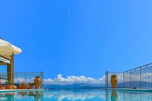 A clear blue sky, a swimming pool with a view of mountains, and potted plants on the poolside. - Villa Triantafyllo in Kentroma (Kentroma)