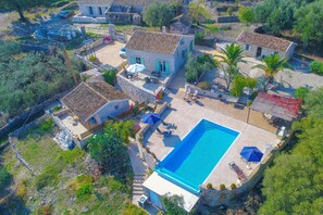 Eine Vogelperspektive auf ein Anwesen mit Swimmingpool, Steinbauten und Außenbereichs-Sitzgelegenheiten.