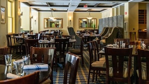A restaurant with multiple dining tables and chairs, a patterned carpet, and ceiling lights. - 5BR Ski-In Condo in Okemo Mountain | Near Lifts! (Ludlow)