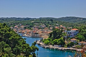 A coastal town with buildings along a marina, surrounded by greenery and hills. - Faros Tria in Gaios with 1 bedrooms and 1 bathrooms (Gaios)