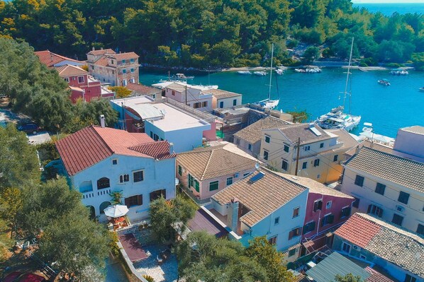 A coastal village with traditional Mediterranean architecture, a marina with boats, and a clear view of the sea. - Villa Eleni Paxos in Gaios (Gaios)