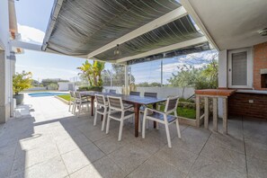An outdoor patio with a dining table and chairs, a small pool, and a brick wall. - Maria in Albufeira with 6 bedrooms and 5 bathrooms (Albufeira)
