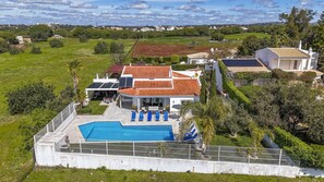 A large house with a swimming pool, surrounded by lush greenery and a view of the countryside. - Maria in Albufeira with 6 bedrooms and 5 bathrooms (Albufeira)