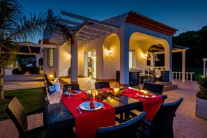 An outdoor dining area with tables set for two, featuring red tablecloths and candles. - Carlivo in Albufeira (Albufeira)