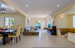 A spacious living area with a dining table, sofa, and a TV. - Carlivo in Albufeira (Albufeira)