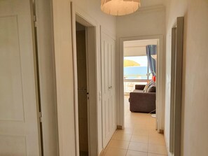 Ein Flur, der zu einem Balkon mit Meerblick führt.
