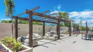 An outdoor patio with a wooden pergola, a sofa set, and a dining area. - Condominium w/ Pool, 450 m fr/ the sea and 650 m fr/ Beto Carrero World - Lavs (Penha)