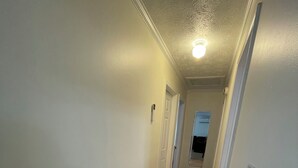 Um corredor com piso de madeira e paredes brancas.