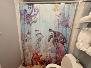 Een douche, handdoeken, zeep, shampoo