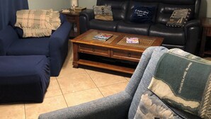 A living room with a blue sofa, a coffee table, and a lamp. - Newly Remodeled Family and Pet Friendly Condo townhouse  in Ocean Walk (St. Simons Island)
