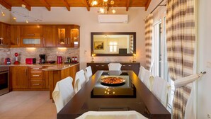 Una cucina moderna con mobili in legno, un tavolo da pranzo con sedie e un grande specchio sopra il tavolo.