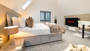 Een moderne slaapkamer met een bed, een televisie en een bureau.