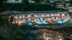 A modern hotel with multiple swimming pools, a rooftop terrace, and a landscaped garden. - Made By The Sea Villa 5 (Mades)