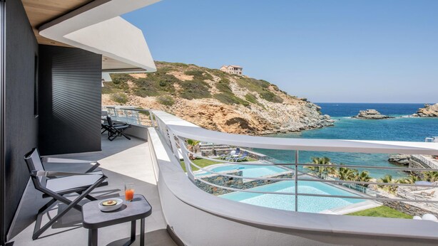 A balcony with a pool, chairs, and a table. - Made By The Sea Villa 4 (Mades)