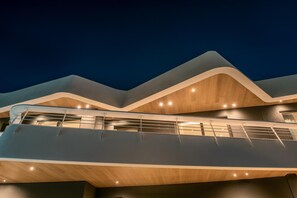 A modern building with a curved roofline and a glass balcony. - Made By The Sea Villa 2 (Mades)