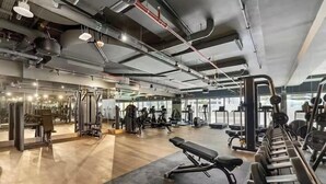 A gym with various exercise equipment, including treadmills and weight machines. - Vogue | Sterling near Dubai Mall | Burj Khalifa (Dubai)