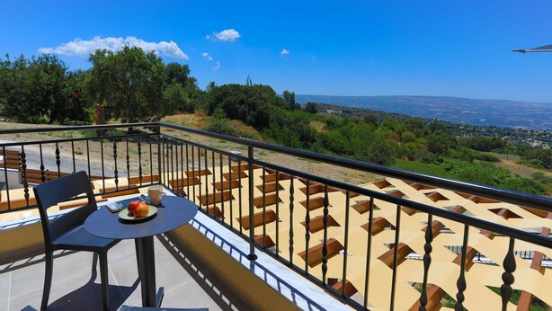 A balcony with a table, chairs, and a view of the landscape. - Villa Kerastis in Malatya (Malatya)