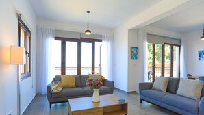 A living room with two sofas, a coffee table, and a large window with curtains. - Villa Salina in Malatya (Malatya)
