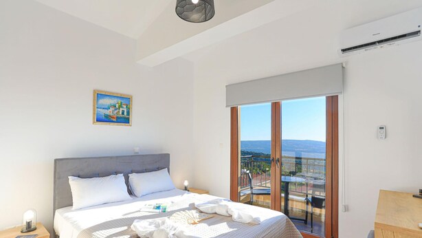 A bedroom with a bed, bedside table, and a view of the outdoors. - Villa Salina in Malatya (Malatya)