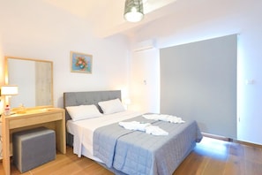 A bedroom with a bed, bedside table, and a small stool. - Villa Aeria in Malatya (Malatya)