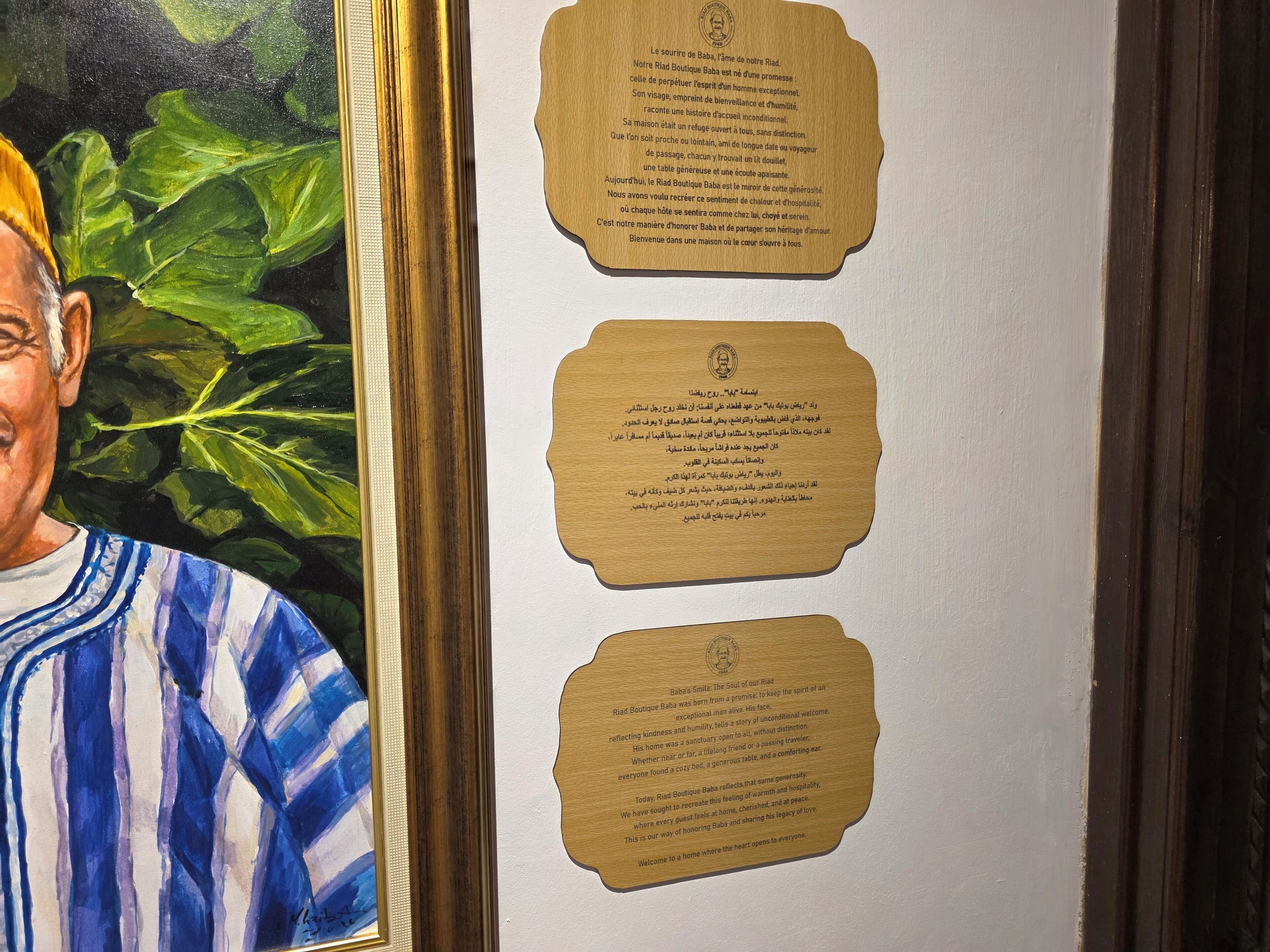 A framed portrait with a wooden plaque containing text.