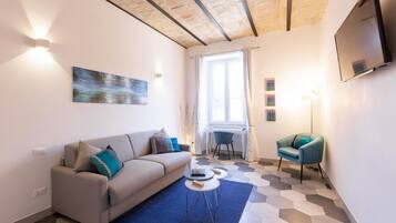 Una sala de estar moderna con un sofá, una mesa de centro y un televisor montado en la pared.