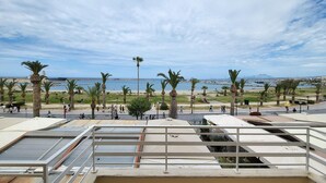 A rooftop terrace with a view of a beach and palm trees. - George's Poet Maisonette (Rethymno)