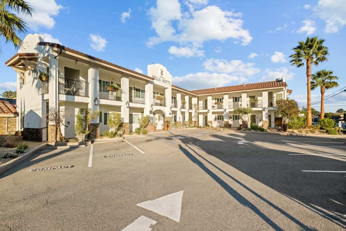 Un hôtel à plusieurs étages, doté d’une façade blanche, de balcons et surplombant un ciel dégagé.
