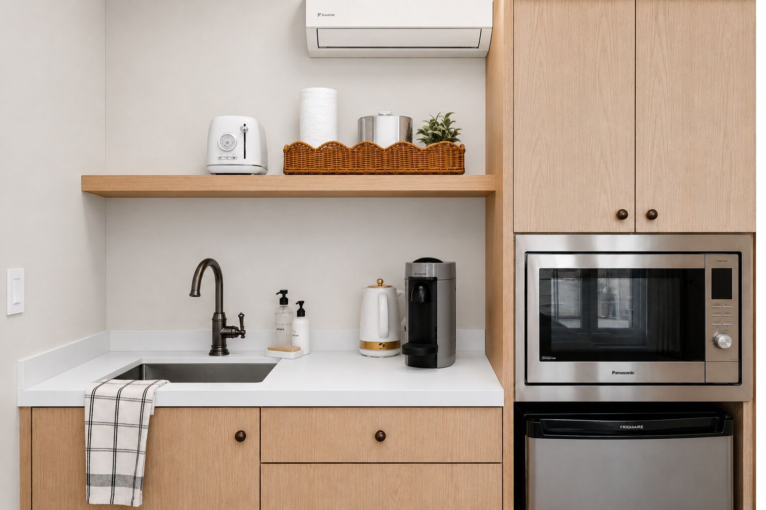 A kitchen with a sink, a coffee maker, a microwave, and a dishwasher.