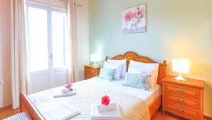 A neatly arranged bedroom with a bed, bedside tables, and a painting on the wall. - Agathi House in Gaios (Gaios)
