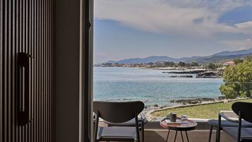 En balkon med udsigt over et kystlandskab, inklusive et vandområde og fjerne bjerge.