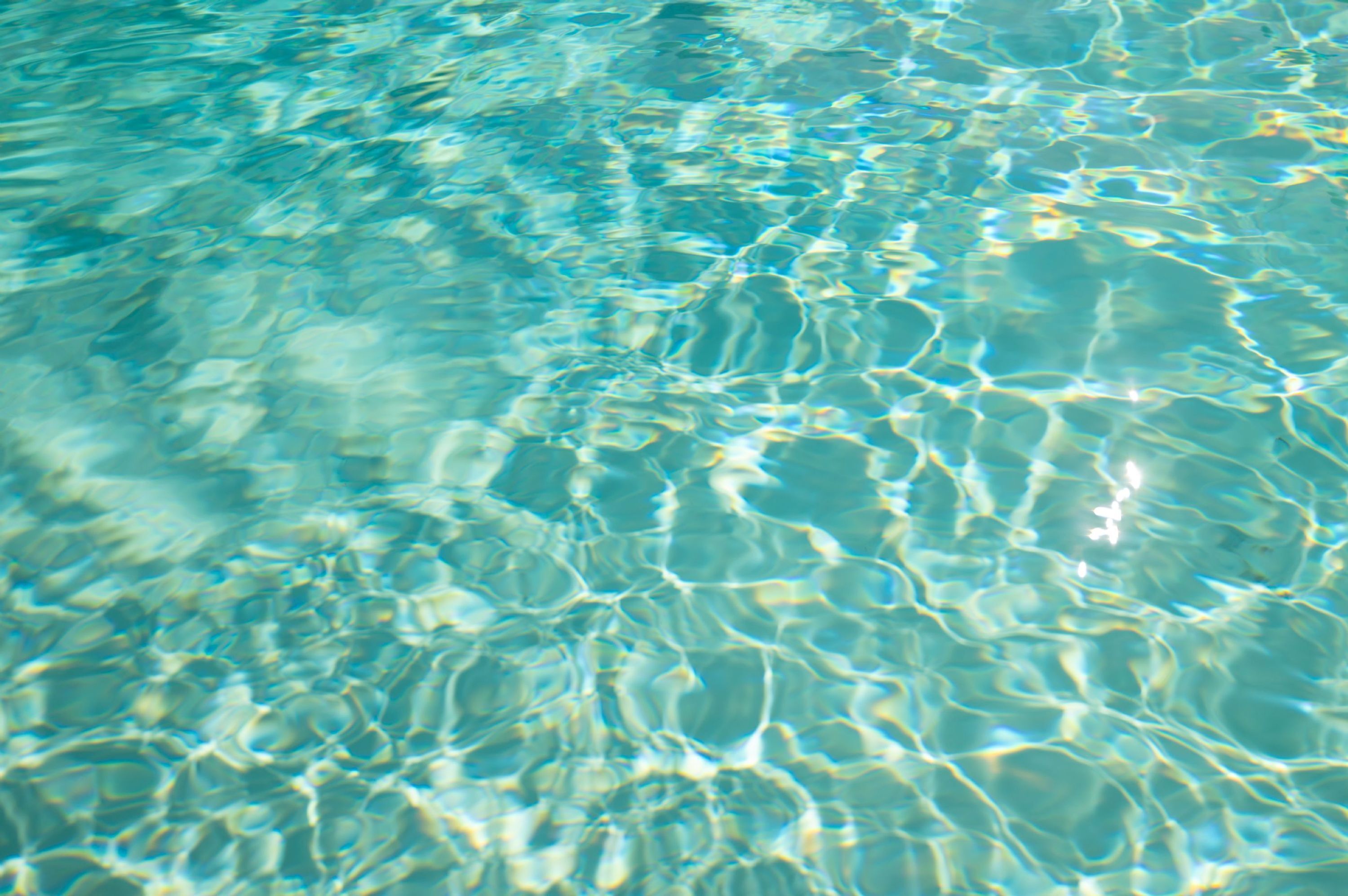 Primer plano de agua cristalina y ondulante, probablemente de una piscina o lago.