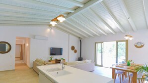 A spacious living area with a kitchen island, a dining table, and a sofa. - Villa Jupeter in Corfu (Corfu)