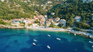 A coastal village with houses, a beach, and boats. - Takis House in Katavolos (Katavolos)