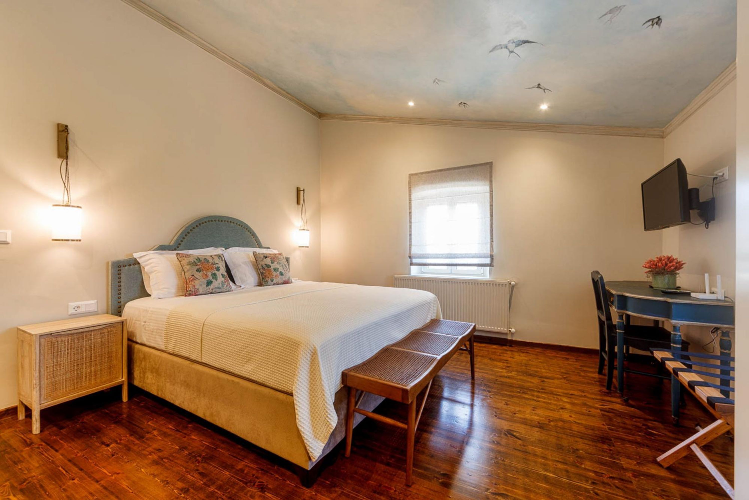 Ein Schlafzimmer mit einem großen Bett, einem Schreibtisch und einem Sessel.