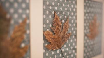 A framed leaf on a polka-dotted background.