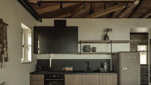 Une cuisine compacte dotée d’un four encastré, d’un réfrigérateur et d’un plan de travail en bois.