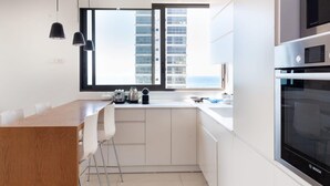 Eine moderne Küche mit weißen Schränken, einer Holz Arbeitsplatte und Edelstahlgeräten.