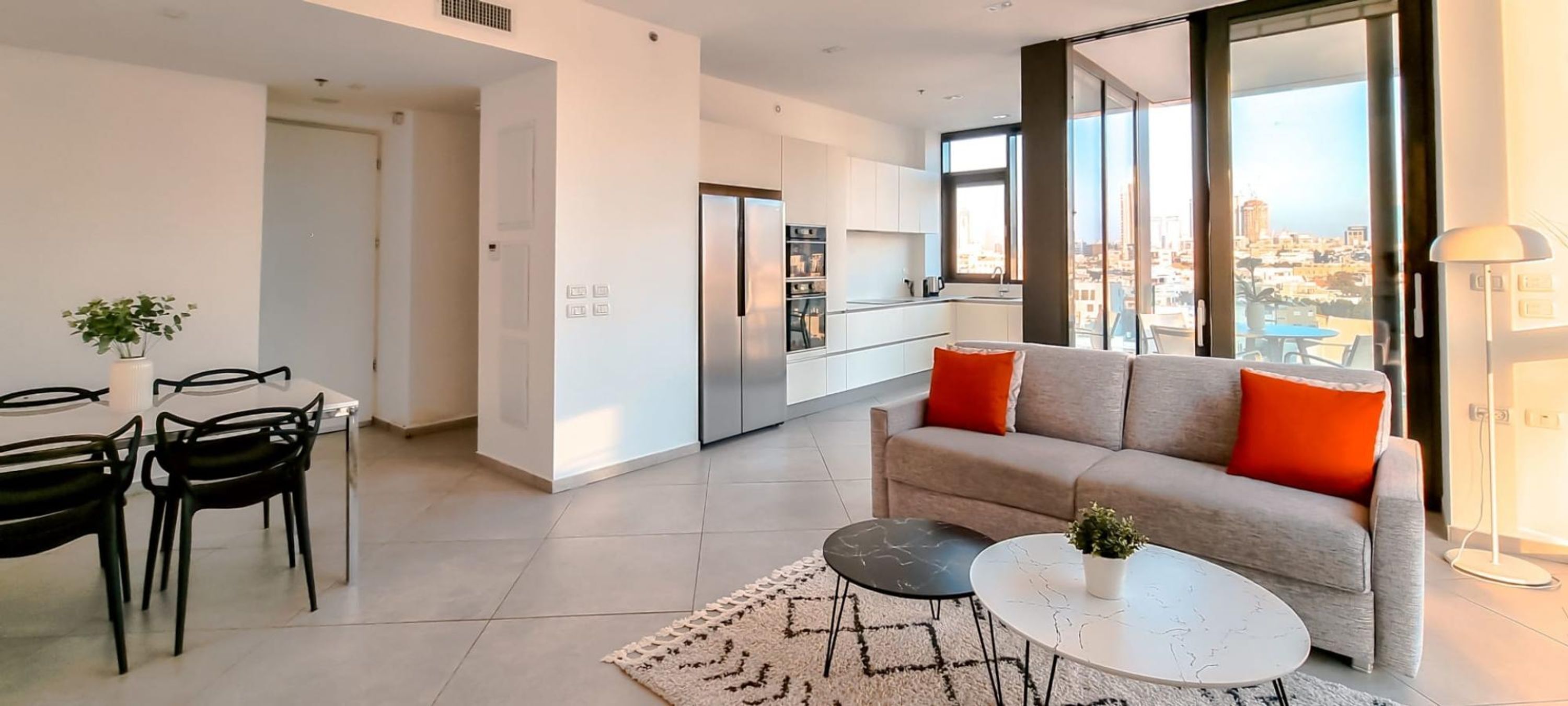 Una sala de estar moderna con sofá, mesa de centro y comedor.