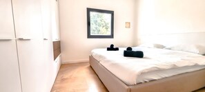 A bedroom with a bed, a window, and a wardrobe. - Kalisher Ophrys in Tel Aviv-Yafo (Tel Aviv-Yafo)