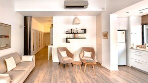 A modern living room with a sofa, two armchairs, a coffee table, and a bookshelf. - Rupin Nacre in Tel Aviv-Yafo (Tel Aviv-Yafo)