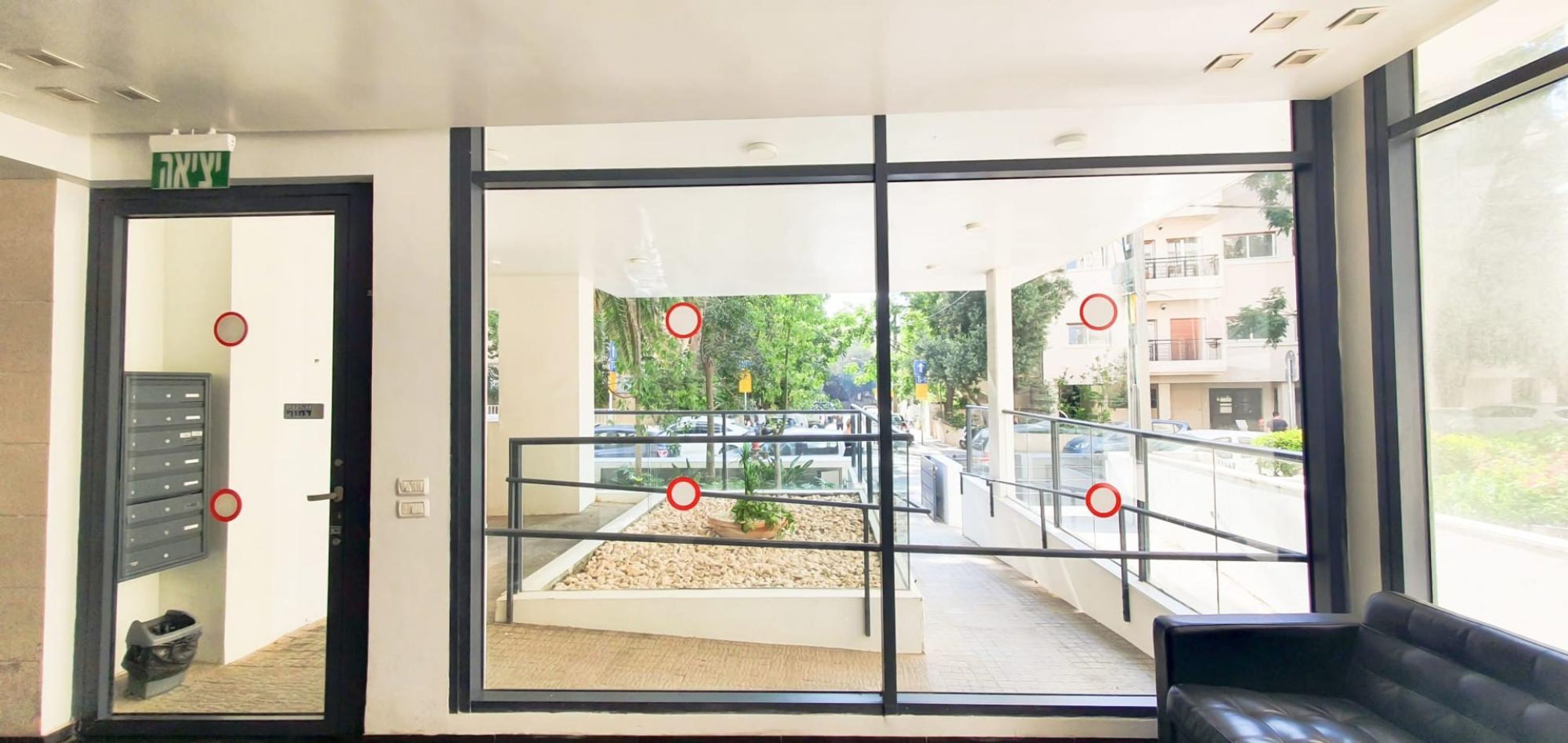 Un hall d’hôtel moderne doté d’un mur en verre, d’un espace salon et d’une vue sur le parking extérieur.