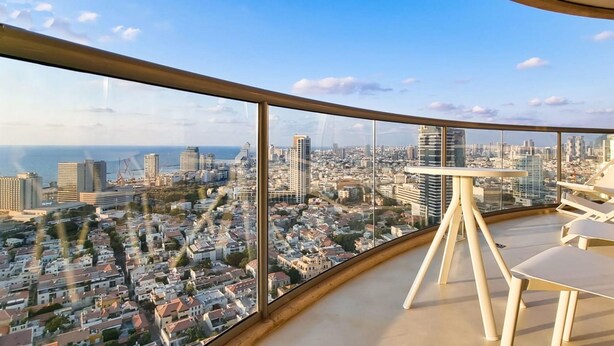 A balcony with a city view, a table, and two chairs. - Blanche Eilat in Tel Aviv-Yafo (Tel Aviv-Yafo)