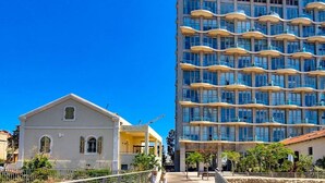 A modern building with multiple balconies and a construction crane nearby. - Blanche Eilat in Tel Aviv-Yafo (Tel Aviv-Yafo)