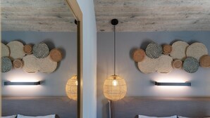 A modern bedroom with a grey headboard, a bedside table, and a wall-mounted light fixture. - Superior Suite with sea views to Argostoli bay (Argostoli)