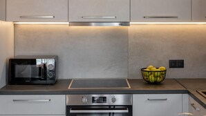 A modern kitchen with a built-in microwave, oven, and a bowl of fruit on the countertop. - Superior Suite with sea views to Argostoli bay (Argostoli)