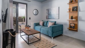 Una sala moderna con un sofá verde azulado, una mesa de centro de madera y un estante montado en la pared con objetos decorativos.