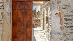 Um corredor de pedra com uma porta de madeira que dá para um quarto.