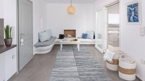 A modern living room with a white sofa, a coffee table, and a large window. - Villa Agali Naxos Glyfada Kastraki (Naxos)